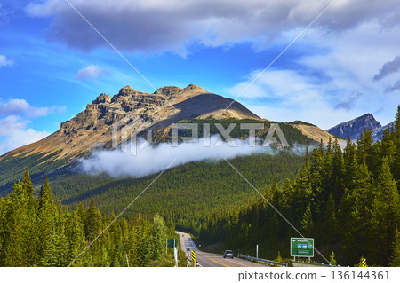 Highway Winding Toward Dramatic Mountain with Cloud and Forest in Banff Canada Highway Winding Toward Dramatic Mountain with Cloud and Forest in Banff Canada 136144361