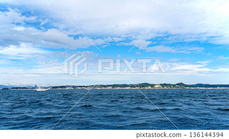 從相模灣眺望三浦半島的海岸線和城市景觀，藍天白雲籠罩其間。 136144394