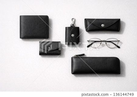 Minimalist flat lay of black leather wallet and small leather items 136144749