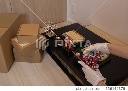 戴著手套的手正在為女兒節裝飾雛人偶。 136144876