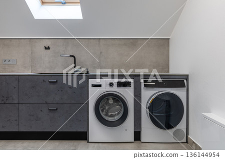 Modern Attic Laundry Room with Washing Machine and Dryer 136144954