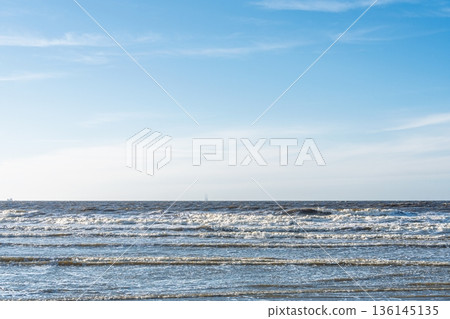 Gentle Waves on the Seashore Under a Bright Blue Sky. Serene Ocean Scene for Relaxation Gentle Waves on the Seashore Under a Bright Blue Sky. Serene Ocean Scene for Relaxation 136145135