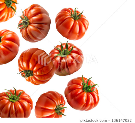 Multiple ripe heirloom tomatoes with ridged textures scattered and on a white background, natural food and healthy eating concept Multiple ripe heirloom tomatoes with ridged textures scattered and on a white background, natural food and healthy eating concept 136147022
