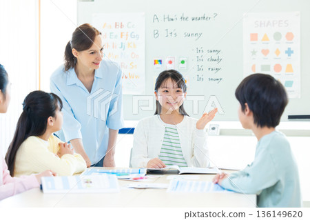 Education A child taking a lesson in an English conversation class and a native teacher Education A child taking a lesson in an English conversation class and a native teacher 136149620