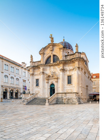 Square at St Blaise Church and people at Stradun Street in the Old city of Dubrovnik, Croatia. Summer morning with soft light. Square at St Blaise Church and people at Stradun Street in the Old city of Dubrovnik, Croatia. Summer morning with soft light. 136149734