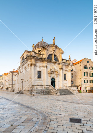 Square at St Blaise Church and people at Stradun Street in the Old city of Dubrovnik, Croatia. Summer morning with soft light. Square at St Blaise Church and people at Stradun Street in the Old city of Dubrovnik, Croatia. Summer morning with soft light. 136149735