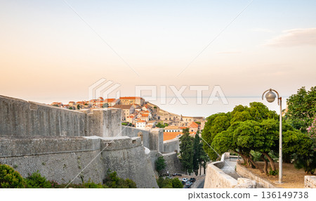 Panoramic view of sunrise over old town of Dubrovnik. Ancient city wall and Minceta tower. Famous tourist destination in Croatia. Summer morning, soft warm light. UNESCO heritage. Panoramic view of sunrise over old town of Dubrovnik. Ancient city wall and Minceta tower. Famous tourist destination in Croatia. Summer morning, soft warm light. UNESCO heritage. 136149738