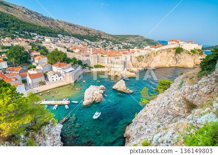 Old city Dubrovnik panorama. View of town roofs, cliff above the sea and small harbor with boats. Old city Dubrovnik panorama. View of town roofs, cliff above the sea and small harbor with boats. 136149803