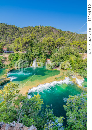 Waterfalls at Krka river, Croatia. Part of the Skradinski Buk waterfall. Famous place in nature park - beautiful tourist destination in Croatia. Fresh green nature, summer weather. Waterfalls at Krka river, Croatia. Part of the Skradinski Buk waterfall. Famous place in nature park - beautiful tourist destination in Croatia. Fresh green nature, summer weather. 136149810