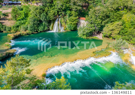 Waterfalls at Krka river, Croatia. Part of the Skradinski Buk waterfall. Famous place in nature park - beautiful tourist destination in Croatia. Fresh green nature, summer weather. 136149811