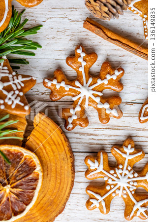 Christmas gingerbread and sweets are placed on wooden desk. Cookies and sweet food in shape of stars and snow flakes. Winter theme, rustic style. Pine trees on the side. Candy stick and other spice. Christmas gingerbread and sweets are placed on wooden desk. Cookies and sweet food in shape of stars and snow flakes. Winter theme, rustic style. Pine trees on the side. Candy stick and other spice. 136149835