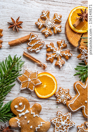 Christmas gingerbread and sweets are placed on wooden desk. Cookies and sweet food in shape of stars and snow flakes. Winter theme, rustic style. Pine trees on the side. Candy stick and other spice. Christmas gingerbread and sweets are placed on wooden desk. Cookies and sweet food in shape of stars and snow flakes. Winter theme, rustic style. Pine trees on the side. Candy stick and other spice. 136149871
