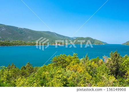 View of beautiful Croatia coast near Makarska. Blue sea with white beach. Isles in the background. Summer weather, blue sky. View of beautiful Croatia coast near Makarska. Blue sea with white beach. Isles in the background. Summer weather, blue sky. 136149908