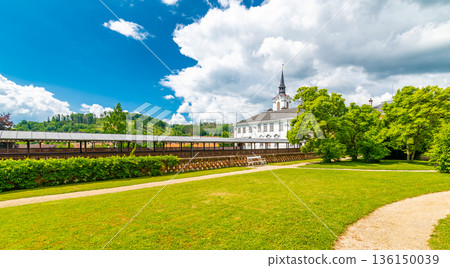 Lysice castle, Czech Republic. Famous baroque castle built in 14th century. Beautiful formal garden, palm trees and flowers. Promenade near the castle. Sunny day, dramatic clouds before storm. Lysice castle, Czech Republic. Famous baroque castle built in 14th century. Beautiful formal garden, palm trees and flowers. Promenade near the castle. Sunny day, dramatic clouds before storm. 136150039
