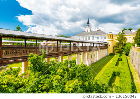 Lysice castle, Czech Republic. Famous baroque castle built in 14th century. Beautiful formal garden, palm trees and flowers. Promenade near the castle. Sunny day, dramatic clouds before storm. Lysice castle, Czech Republic. Famous baroque castle built in 14th century. Beautiful formal garden, palm trees and flowers. Promenade near the castle. Sunny day, dramatic clouds before storm. 136150042