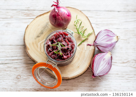 Red onion marmalade placed on wooden trunk with wood texture background. Jam from onion is delicious part of French cuisine. Homemade jam in transparent glass, vibrant colors, soft light. Red onion marmalade placed on wooden trunk with wood texture background. Jam from onion is delicious part of French cuisine. Homemade jam in transparent glass, vibrant colors, soft light. 136150114