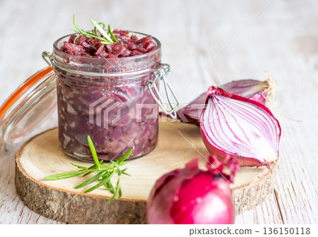 Red onion marmalade placed on wooden trunk with wood texture background. Jam from onion is delicious part of French cuisine. Homemade jam in transparent glass, vibrant colors, soft light. Red onion marmalade placed on wooden trunk with wood texture background. Jam from onion is delicious part of French cuisine. Homemade jam in transparent glass, vibrant colors, soft light. 136150118