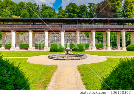 Lysice castle, Czech Republic. Famous baroque castle built in 14th century. Beautiful formal garden, palm trees and flowers. Promenade near the castle. Sunny day, dramatic clouds before storm. Lysice castle, Czech Republic. Famous baroque castle built in 14th century. Beautiful formal garden, palm trees and flowers. Promenade near the castle. Sunny day, dramatic clouds before storm. 136150303