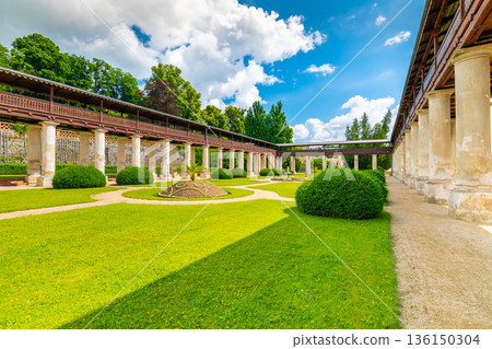 Lysice castle, Czech Republic. Famous baroque castle built in 14th century. Beautiful formal garden, palm trees and flowers. Promenade near the castle. Sunny day, dramatic clouds before storm. Lysice castle, Czech Republic. Famous baroque castle built in 14th century. Beautiful formal garden, palm trees and flowers. Promenade near the castle. Sunny day, dramatic clouds before storm. 136150304