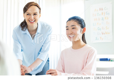 Education A child taking a lesson in an English conversation class and a native teacher 136150308