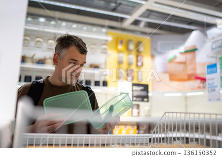 Man shopping for plastic containers 136150352