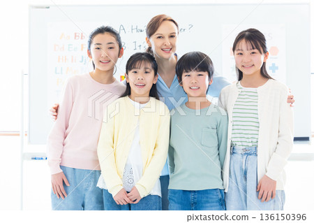 Education: Portrait of a child taking a lesson in an English conversation class and a native teacher Education: Portrait of a child taking a lesson in an English conversation class and a native teacher 136150396