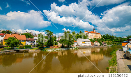 Panoramic view of castle above river in Ledec nad Sazavou. Sazava river is famous target for kayaking. Summer weather with dramatic clouds. Czech Republic. 136150452
