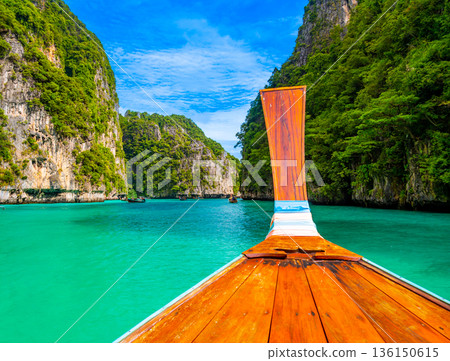 View of Pi Leh lagoon (also known as Green Lagoon) at Ko Phi Phi islands, Thailand. View from typical long tailed boat. Typical Thai picture of tropical paradise. Limestone rock and turquoise water. View of Pi Leh lagoon (also known as Green Lagoon) at Ko Phi Phi islands, Thailand. View from typical long tailed boat. Typical Thai picture of tropical paradise. Limestone rock and turquoise water. 136150615