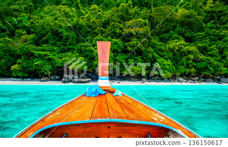 View of monkey beach at Ko Phi Phi islands, Thailand. Famous tropical beach with white sand and turquoise water. View from long tail boat. Summer paradise. View of monkey beach at Ko Phi Phi islands, Thailand. Famous tropical beach with white sand and turquoise water. View from long tail boat. Summer paradise. 136150617