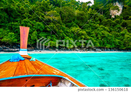 View of monkey beach at Ko Phi Phi islands, Thailand. Famous tropical beach with white sand and turquoise water. View from long tail boat. Summer paradise. View of monkey beach at Ko Phi Phi islands, Thailand. Famous tropical beach with white sand and turquoise water. View from long tail boat. Summer paradise. 136150618