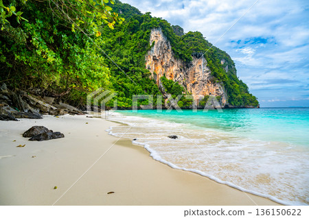 View of monkey beach at Ko Phi Phi islands, Thailand. Famous tropical beach with white sand and turquoise water. View from long tail boat. Summer paradise. View of monkey beach at Ko Phi Phi islands, Thailand. Famous tropical beach with white sand and turquoise water. View from long tail boat. Summer paradise. 136150622