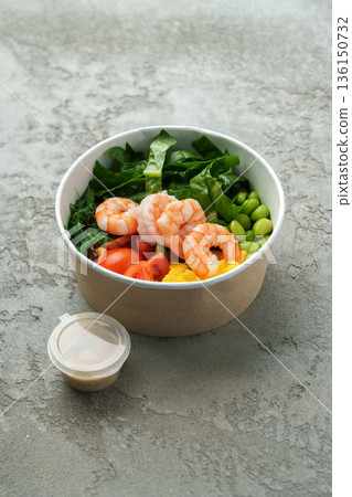 Fresh shrimp salad with vegetables served in a bowl on a gray surface Fresh shrimp salad with vegetables served in a bowl on a gray surface 136150732