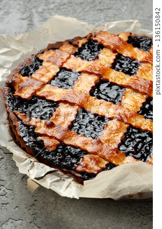 Blackberry pie baked with a golden crust and dark filling on a baking sheet 136150842