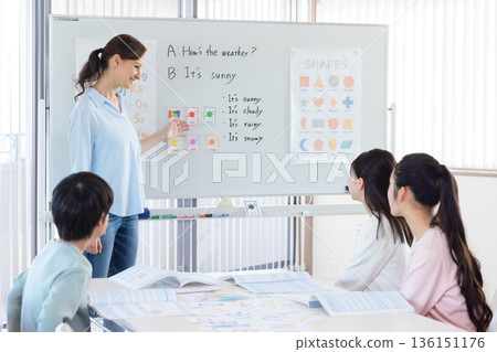 Education A child taking a lesson in an English conversation class and a native teacher Education A child taking a lesson in an English conversation class and a native teacher 136151176