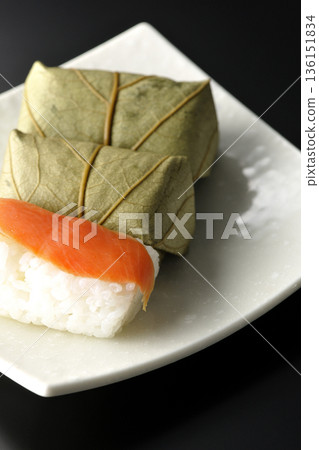Salmon and oyster sushi photographed against a black background 136151834