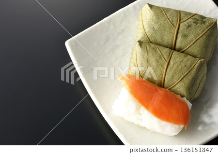 Salmon and oyster sushi photographed against a black background 136151847