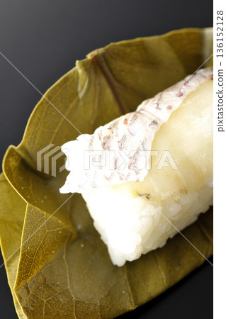 Sea bream oyster sushi photographed against a black background Sea bream oyster sushi photographed against a black background 136152128