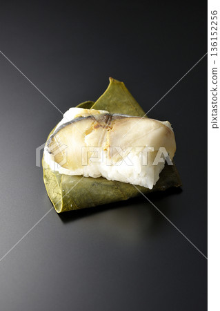 Mackerel persimmon leaf sushi photographed against a black background Mackerel persimmon leaf sushi photographed against a black background 136152256
