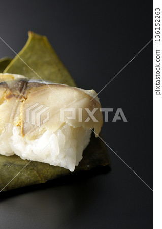 Mackerel persimmon leaf sushi photographed against a black background Mackerel persimmon leaf sushi photographed against a black background 136152263
