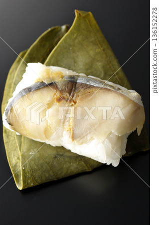 Mackerel persimmon leaf sushi photographed against a black background 136152278