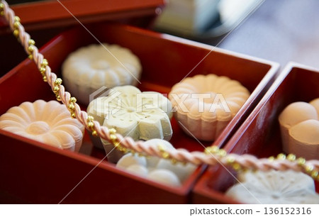 盛放在朱紅色漆器容器中的傳統日式點心 136152316