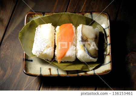 Salmon, sea bream and mackerel sushi wrapped in persimmon leaves Salmon, sea bream and mackerel sushi wrapped in persimmon leaves 136153461
