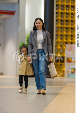 mother and child girl walking with shopping bag in a department store 136153502