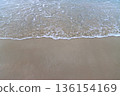 Ocean water moving gently on the sand 136154169