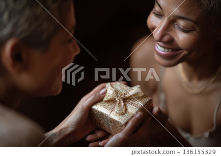 two middle-aged women's hands exchanging gift on valentine day 136155329
