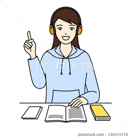 A woman studying with a smile and pointing at something while wearing earmuffs for hearing loss 136155378