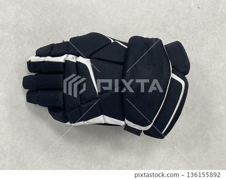 a hockey glove on the floor in a sports locker room 136155892