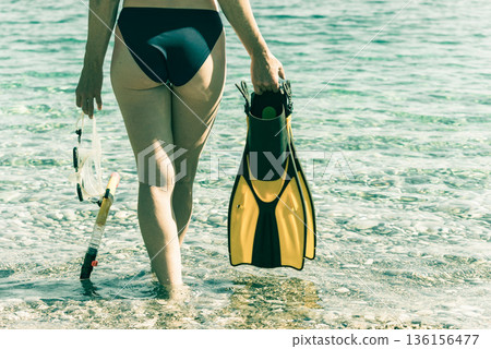 Woman with flippers snorkeling tube on beach Woman with flippers snorkeling tube on beach 136156477