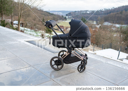 Baby stroller standing on terrace with scenic view. Family lifestyle, parenthood and calm everyday moment 136156666