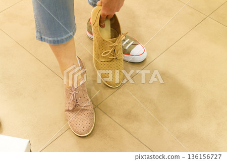 Unrecognizable woman trying on shoes Unrecognizable woman trying on shoes 136156727